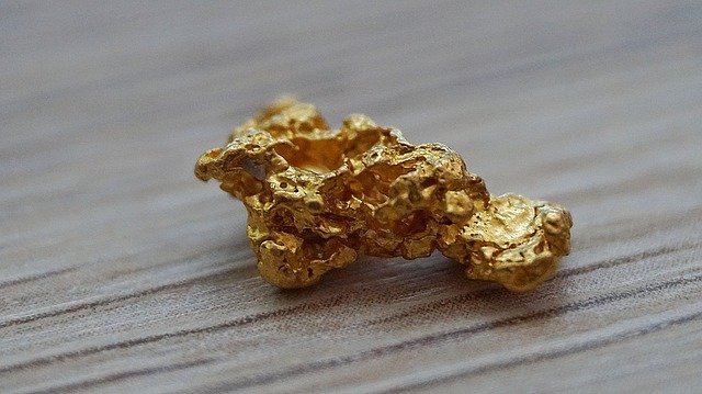 גוש זהב גולמי קטן מונח על שולחן